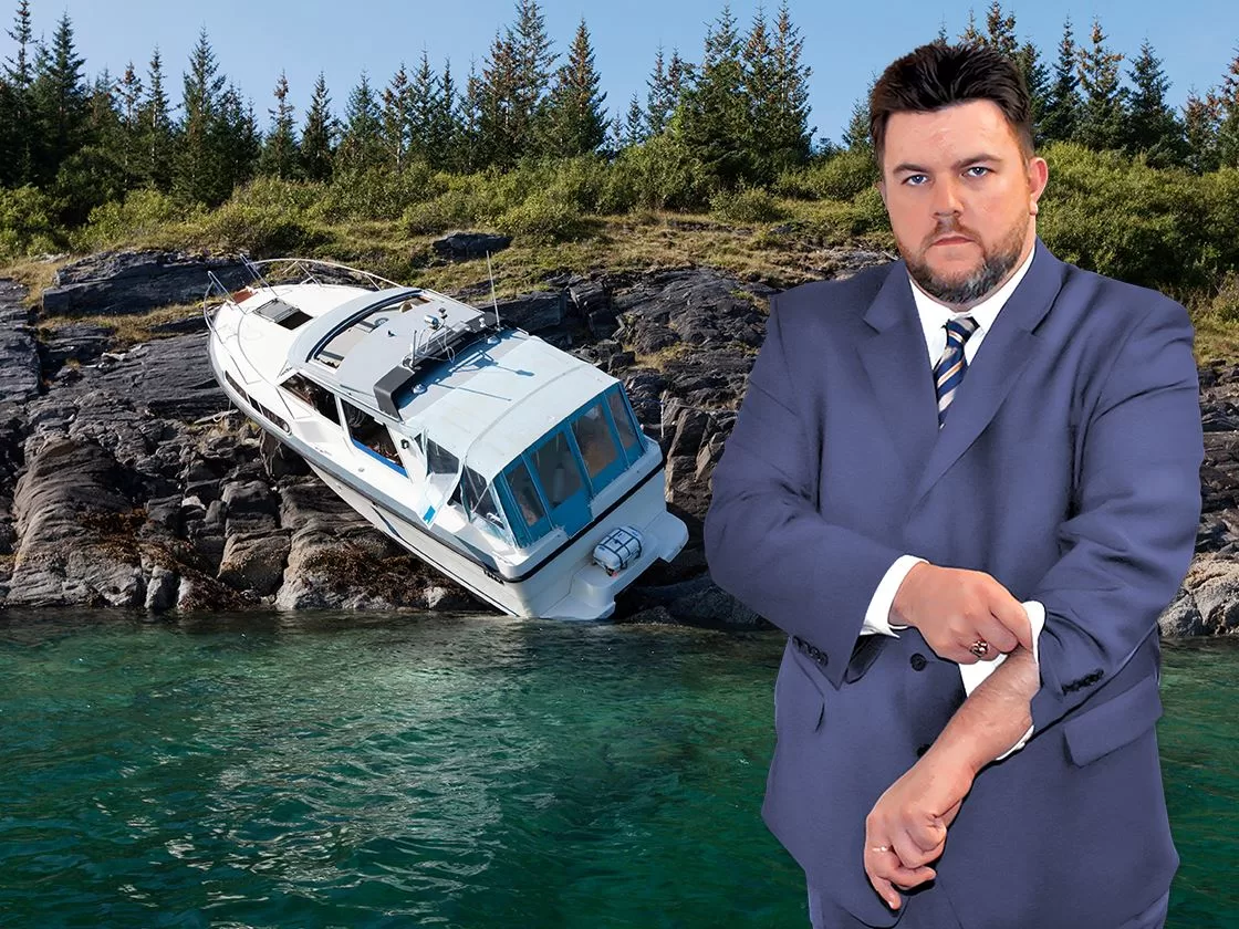 Ron Sholes, Jacksonville boating accident lawyer, near a boat involved in a collision.