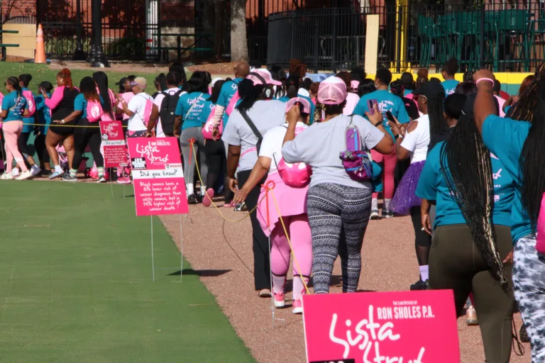 Sista Strut participants walking to registration at Jacksonville breast cancer walk, sponsored by Ron Sholes, P.A.
