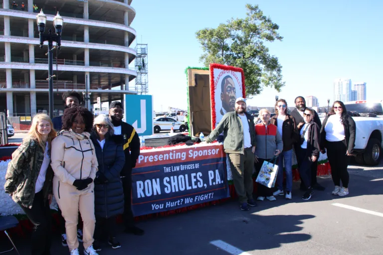 Ron Sholes staff standing by firm float at Jacksonville Martin Luther King Day Parade.